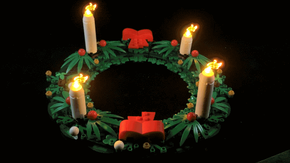 Animated gif showing four flickering LEGO candles with lights on in front of a black background.